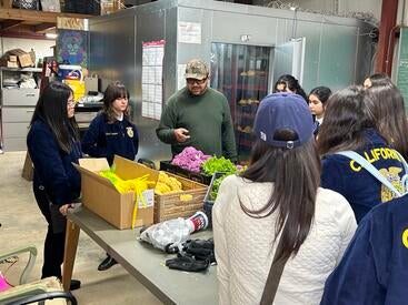 Students receiving produce from R'Garden