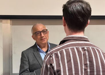 Amir H. Hoveyda speaking with a student at UC Riverside.