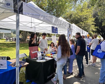 CNAS transfer students attending a booth at Highlander Day.