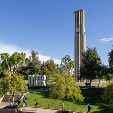 UCR sign with belltower and students